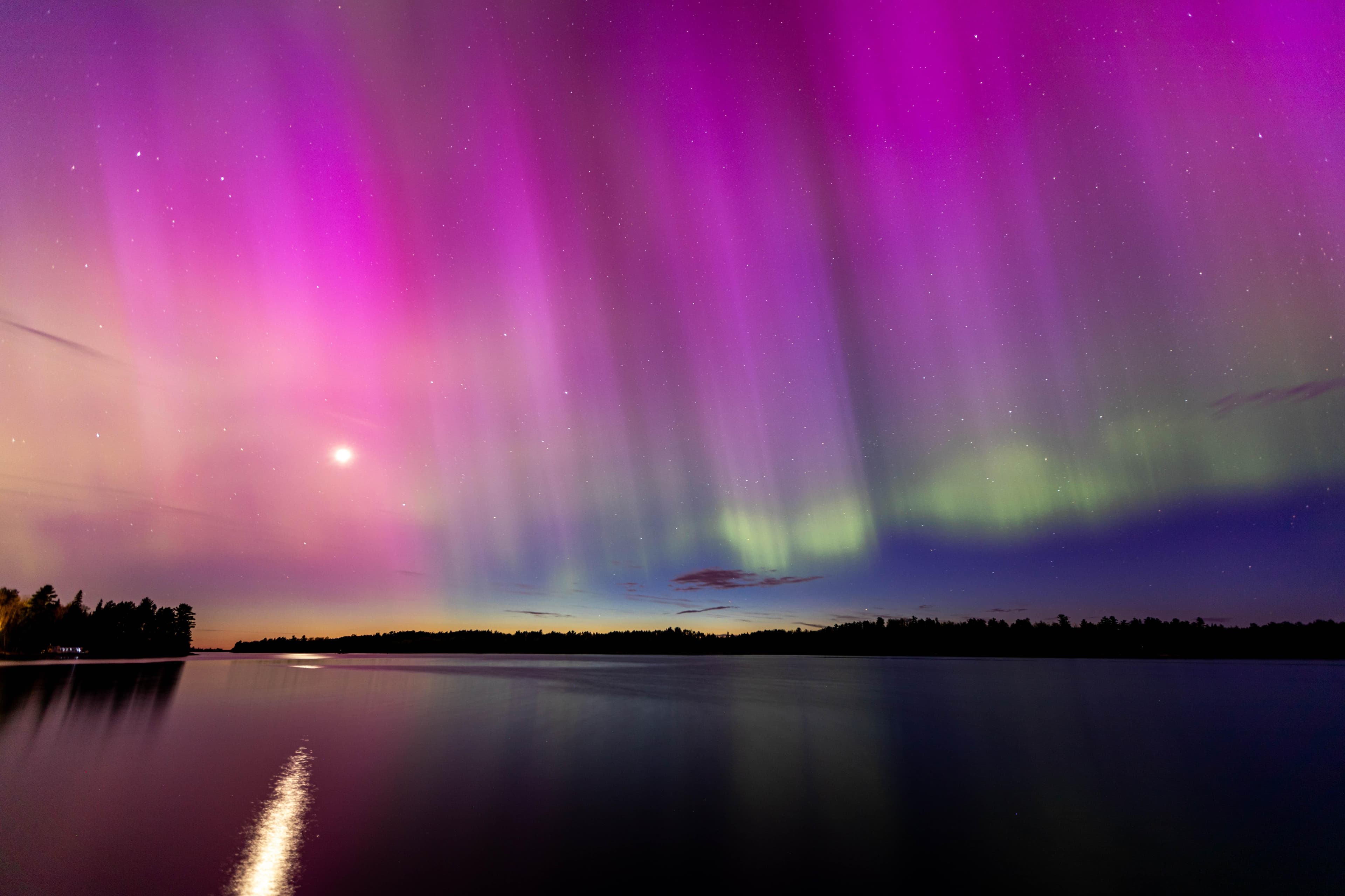 Photograph of northern lights over a lake.